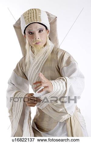 Stock Photo - Portrait of a mid adult man wearing traditional clothing pointing. Fotosearch