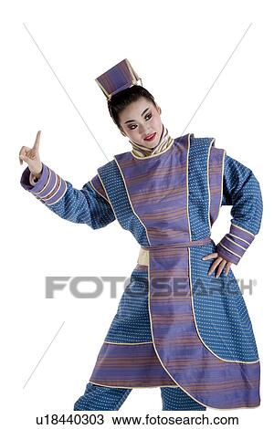 Stock Image - Portrait of a young man wearing traditional clothing pointing up. Fotosearch