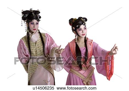 Two women wearing traditional clothing pointing up View Large Photo Image Stock Photography - Two women wearing traditional clothing pointing up. Fotosearch