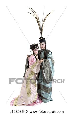 Stock Image - Woman and man wearing traditional clothing holding together. Fotosearch