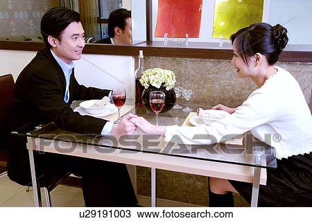 Stock Image - Couple at dinning table. Fotosearch