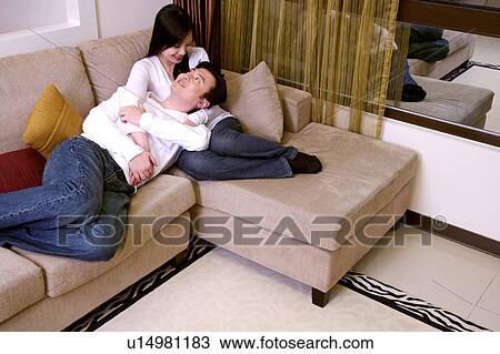 Stock Image - Couple bonding on sofa. Fotosearch