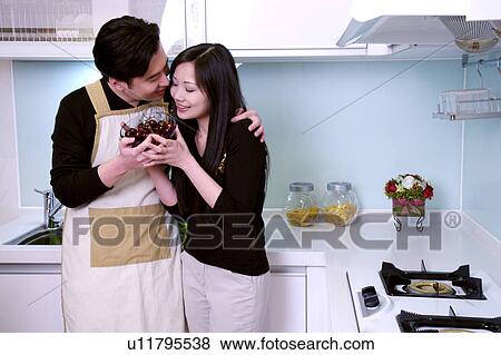 Couple embracing holding a bowl of berries View Large Photo Image Stock Photo - Couple embracing holding a bowl of berries. Fotosearch