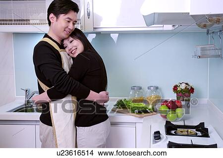 Picture - Couple embracing in kitchen. Fotosearch