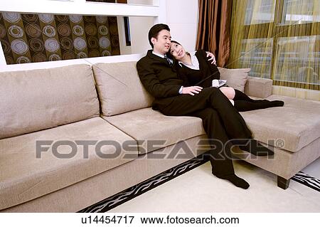 Stock Photo - Couple embracing on sofa. Fotosearch