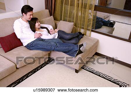 Couple embracing on sofa View Large Photo Image Stock Photo - Couple embracing on sofa. Fotosearch