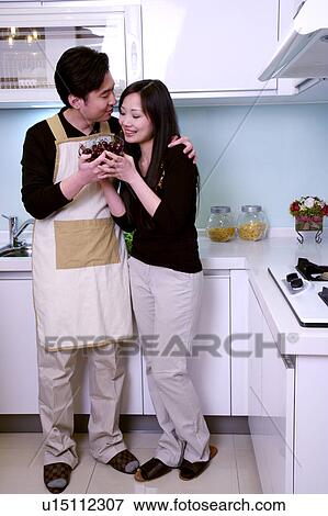 Couple holding bowl of cherries in kitchen View Large Photo Image Stock Photo - Couple holding bowl of cherries in kitchen. Fotosearch