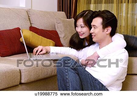 Couple looking at laptop View Large Photo Image Stock Photography - Couple looking at laptop. Fotosearch