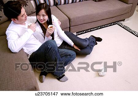 Couple sitting on floor drinking tea View Large Photo Image Stock Photo - Couple sitting on floor drinking tea. Fotosearch