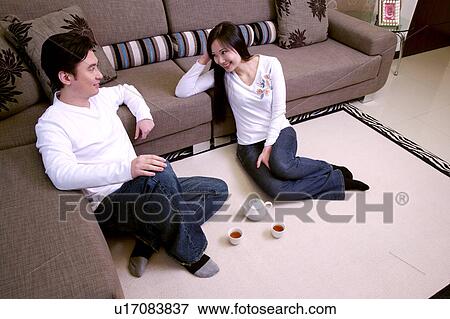 Couple sitting on floor, tea set aside View Large Photo Image Stock Photo - Couple sitting on floor, tea set aside. Fotosearch