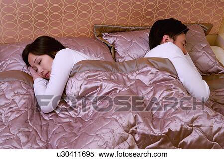 Stock Photography - Couple sleeping on bed. Fotosearch