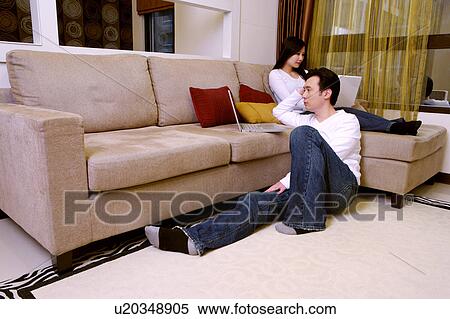 Stock Photography - Couple with laptop in living room. Fotosearch