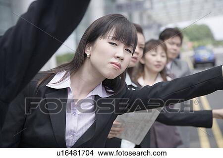 Business executives hailing a taxi at an airport View Large Photo Image Picture - Business executives hailing a taxi at an airport. Fotosearch