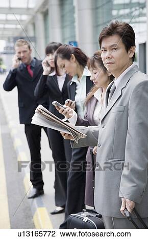 Business executives waiting for taxi at an airport View Large Photo Image Stock Image - Business executives waiting for taxi at an airport. Fotosearch