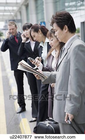 Business executives waiting for taxi at an airport View Large Photo Image Stock Photo - Business executives waiting for taxi at an airport. Fotosearch