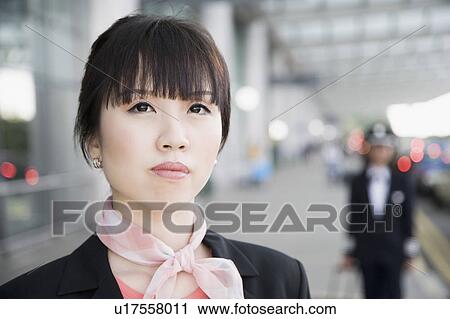 Stock Image - Close-up of a female cabin crew looking up. Fotosearch