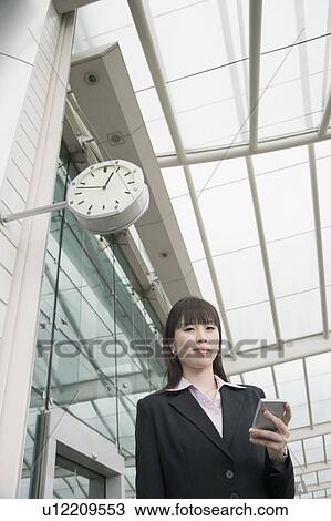 Low angle view of a businesswoman holding a personal data assistant and waiting at an airport lounge View Large Photo Image Stock Image - Low angle view of a businesswoman holding a personal data assistant and waiting at an airport lounge. Fotosearch