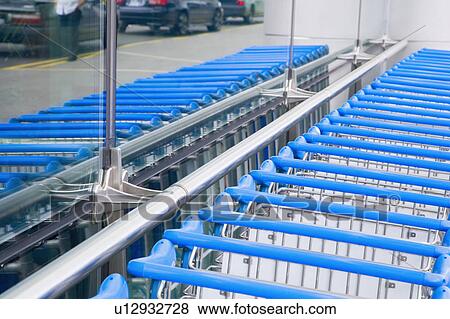Luggage carts in a row at an airport View Large Photo Image Stock Photo - Luggage carts in a row at an airport. Fotosearch