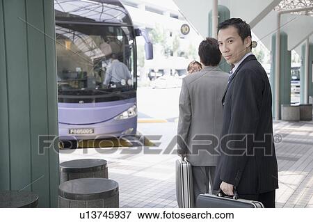 Stock Photo - Portrait of a businessman holding a suitcase and walking. Fotosearch