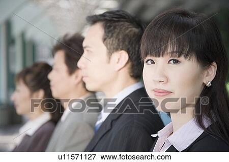 Stock Photo - Portrait of a businesswoman with her three colleagues beside her. Fotosearch
