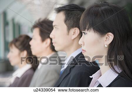 Picture - Side profile of four business executives side by side. Fotosearch