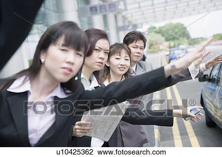Business executives hailing a taxi at an airport View Large Photo Image Stock Image - Business executives hailing a taxi at an airport. Fotosearch
