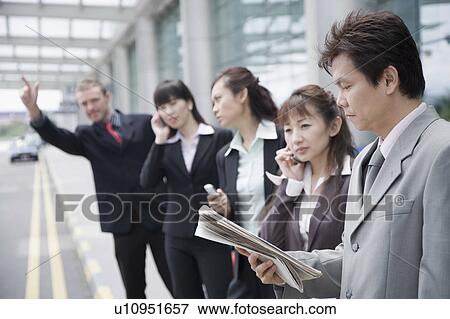 Business executives hailing a taxi at an airport View Large Photo Image Stock Photo - Business executives hailing a taxi at an airport. Fotosearch