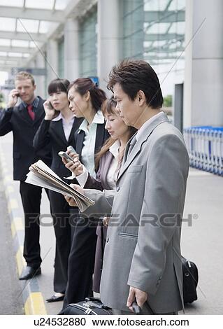 Business executives waiting for taxi at an airport View Large Photo Image Stock Image - Business executives waiting for taxi at an airport. Fotosearch