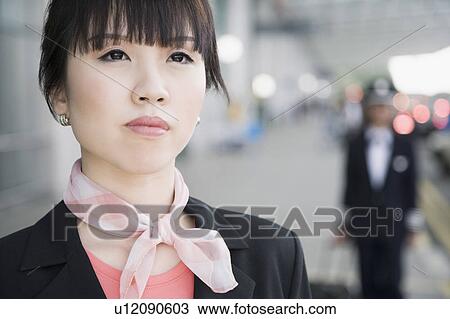 Stock Image - Close-up of a female cabin crew looking up. Fotosearch