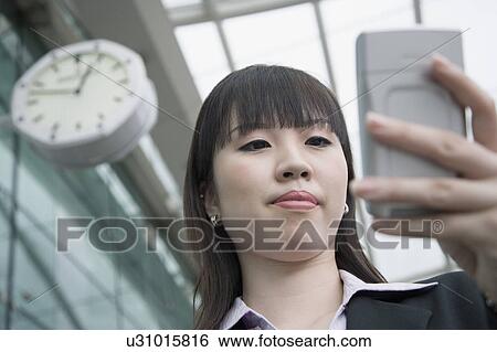 Low angle view of a businesswoman using a palmtop and waiting at an airport lounge View Large Photo Image Stock Photograph - Low angle view of a businesswoman using a palmtop and waiting at an airport lounge. Fotosearch