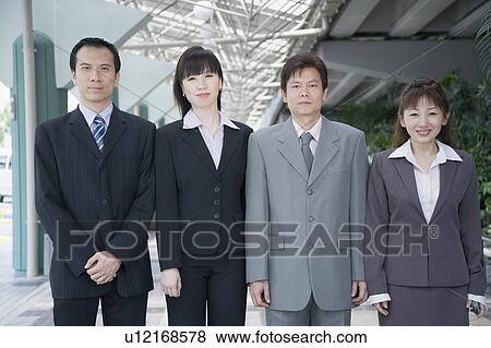 Stock Photo - Portrait of four business executives standing side by side. Fotosearch