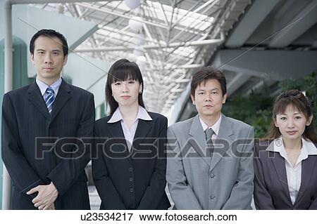 Stock Photo - Portrait of four business executives standing side by side. Fotosearch