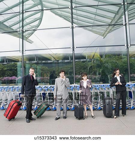 Two businesswomen with two businessmen waiting at an airport View Large Photo Image Stock Image - Two businesswomen with two businessmen waiting at an airport. Fotosearch