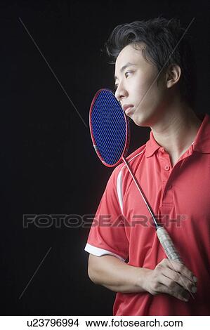 Picture - Close-up of a young man holding a badminton racket. Fotosearch
