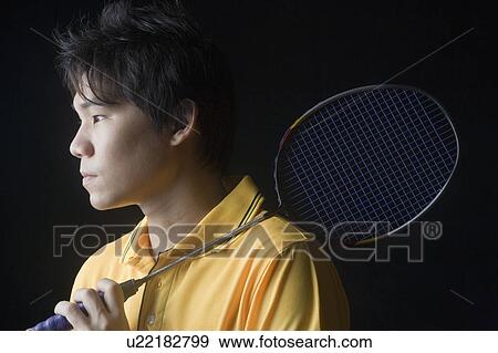 Close-up of a young man holding a badminton racket View Large Photo Image Stock Photo - Close-up of a young man holding a badminton racket. Fotosearch