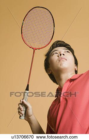 Close-up of a young man playing badminton View Large Photo Image Stock Image - Close-up of a young man playing badminton. Fotosearch