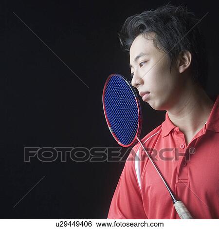 Close-up of a young man with a badminton racket View Large Photo Image Stock Photograph - Close-up of a young man with a badminton racket. Fotosearch