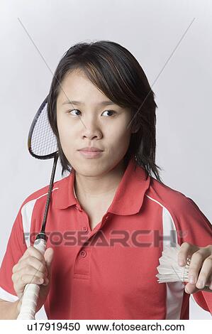 Stock Image - Close-up of a young woman holding a badminton racket and a shuttlecock. Fotosearch