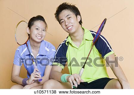Portrait of a young couple holding badminton rackets and smiling View Large Photo Image Stock Photo - Portrait of a young couple holding badminton rackets and smiling. Fotosearch