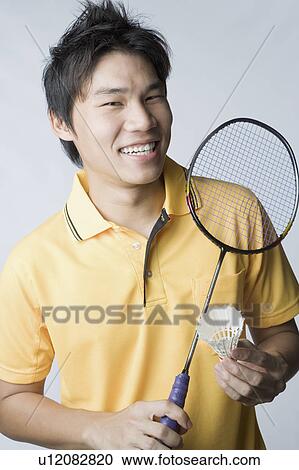 Portrait of a young man holding a badminton racket and a shuttlecock View Large Photo Image Stock Image - Portrait of a young man holding a badminton racket and a shuttlecock. Fotosearch