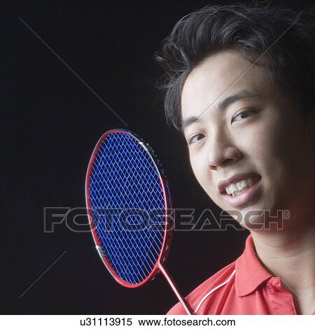 Stock Photography - Portrait of a young man with a badminton racket. Fotosearch