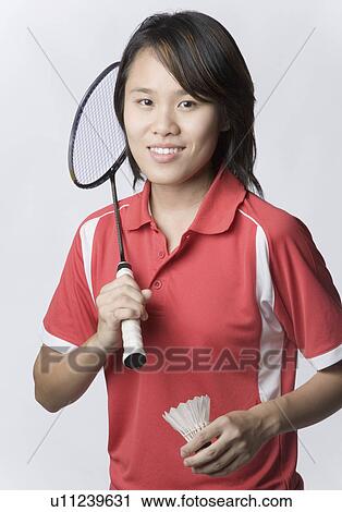 Stock Image - Portrait of a young woman holding a badminton racket and a shuttlecock. Fotosearch