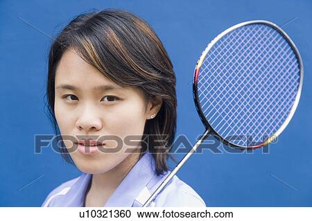 Stock Image - Portrait of a young woman with a badminton racket. Fotosearch