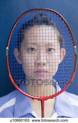 Stock Image - Portrait of a young woman with a badminton racket. Fotosearch