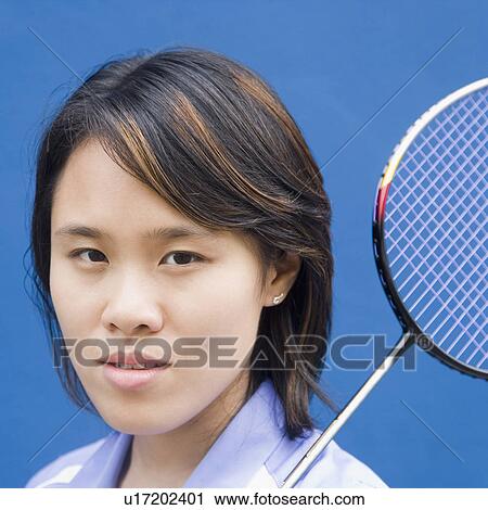 Stock Image - Portrait of a young woman with a badminton racket. Fotosearch