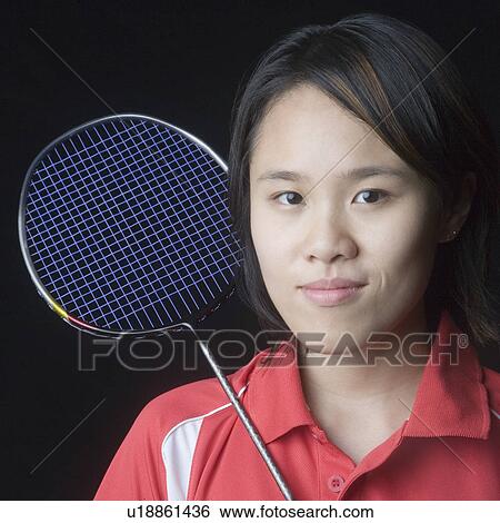 Stock Photograph - Portrait of a young woman with a badminton racket. Fotosearch