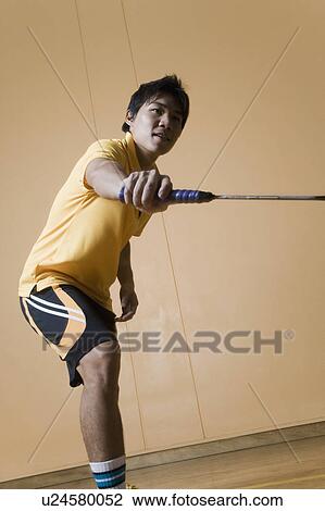Side profile of a young man playing badminton View Large Photo Image Stock Image - Side profile of a young man playing badminton. Fotosearch