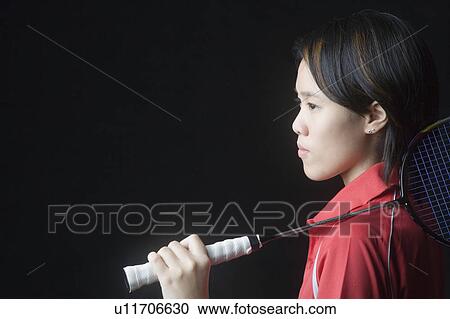 Side profile of a young woman holding a badminton racket View Large Photo Image Stock Image - Side profile of a young woman holding a badminton racket. Fotosearch