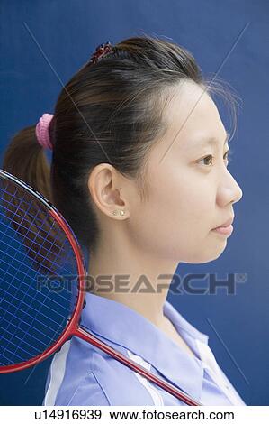 Stock Photo - Side profile of a young woman with a badminton racket. Fotosearch