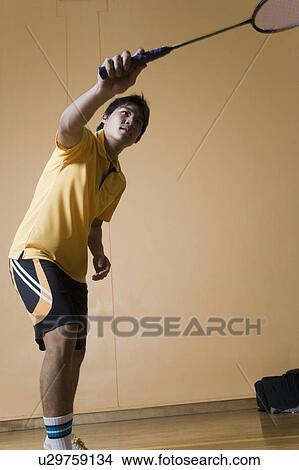 Picture - Young man playing badminton. Fotosearch